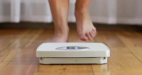 Person Steps on Scale to Measure Weight