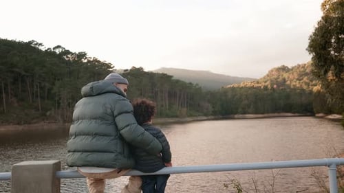 Père et fils nouent des liens autour d'une vue sereine sur le lac par une journée froide