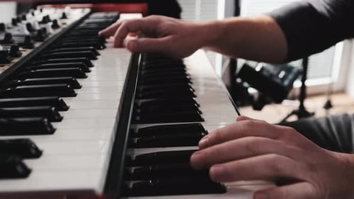 Hands Play Keyboard Musical Instrument in Music Studio