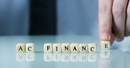 Macro au ralenti du mot « Finance » composée de blocs de lettres en bois. Concept de carte financière