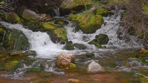 Waterfalls With Mossy Rocks Flowing To The River. - slow motion, pan right
