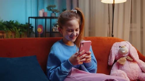 Girl Sits on Couch Using Mobile Phone