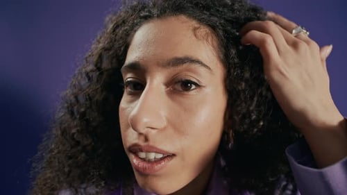 Woman with Voluminous Curls Poses in Purple