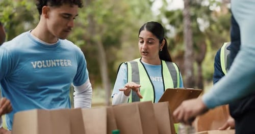 NGO, volunteers and people with clipboard, park and listening to organizer for social