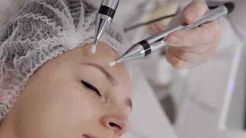 Cosmetologist Doctor Makes Woman Micro Currents Face Therapy Using Electrical Impulses in Spa Salon
