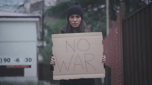 The Female is Holding a Poster Made of Cardboard with the Inscription No War Stand with Ukraine