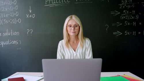 Woman Teaching Math Online from Classroom with Laptop