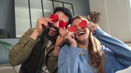 Playful Couple with Hearts Celebrates at Home