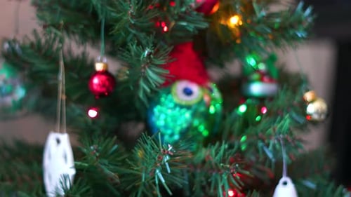 Close up shot of an owl ornament hanging on a Christmas Tree