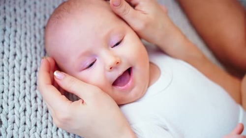A Delightful Baby Beams with Joy As a Loving Caregiver Holds Them Close in a Warm and Inviting