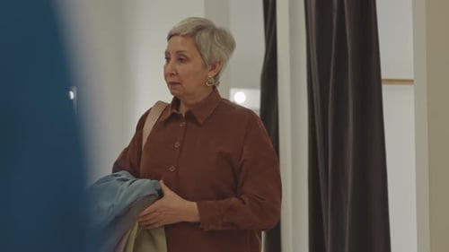 Woman Walking out of Fitting Room in Clothes Store
