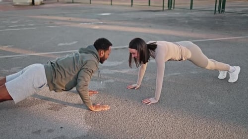 Personal Trainers Doing Pushups and Giving High Five Outdoors