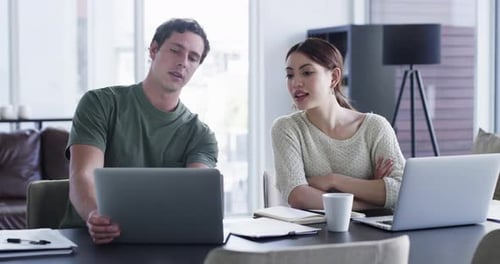 Young Adults Working Collaboratively from Home on Laptops