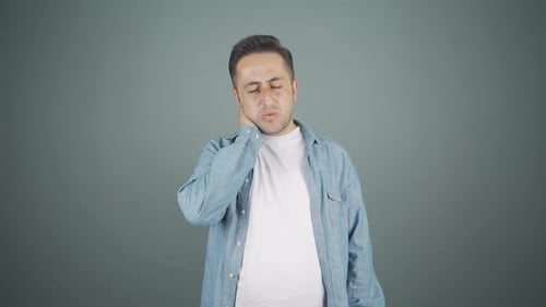 Man Massaging Sore Neck in Studio