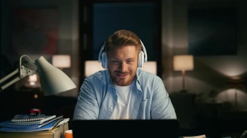 Man Video Chatting On Laptop At Night