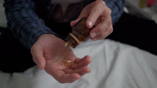 Pills Poured into Hand from Bottle