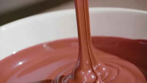 Appareil portatif au ralenti, versant le produit fondu dans un bol. Gros plan