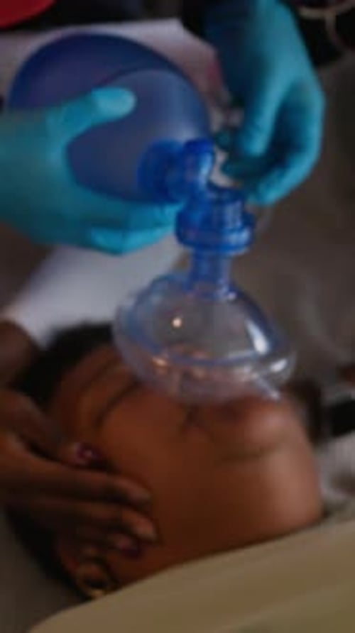 Dos paramédicos suministran oxígeno a una mujer mayor inconsciente a través de una máscara