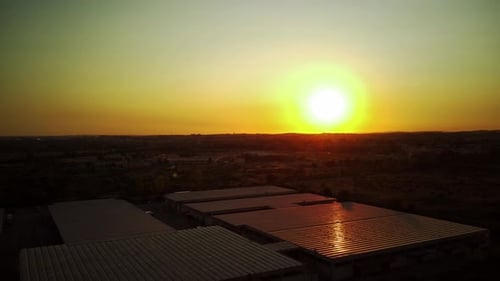 Flight at Sunset Over Warehouses in an Industrial Area
