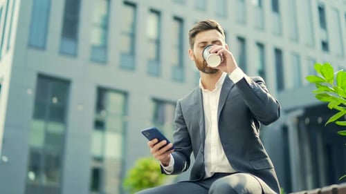 Man in Suit Using Phone Near Office Building