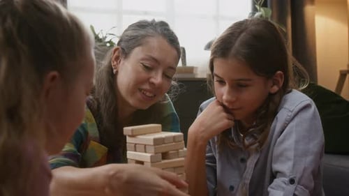Cheerful Mom Playing Wooden Blocks Game with Children at Home