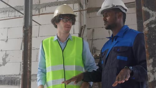 Two Men Discuss Construction Plans in Building