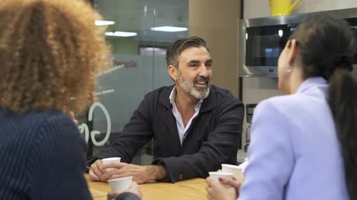 Happy Colleagues Drinking Coffee and Talking in Office
