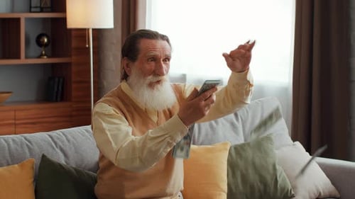 Ecstatic Senior Man Tossing Money on Couch