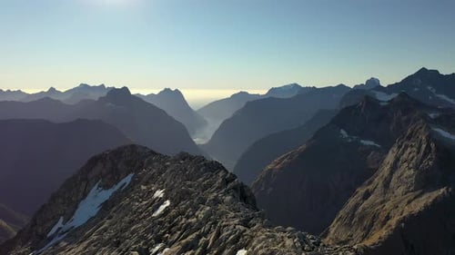 Aerial view flying over a rocky peak in the epic mountain wilderness of the Southern Alps in New Zea