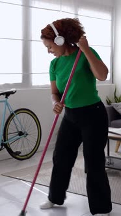 Woman Sweeping and Singing With Broom at Home