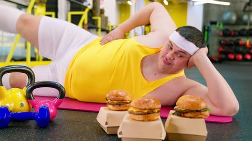 Man Lies Next to Hamburgers in Gym