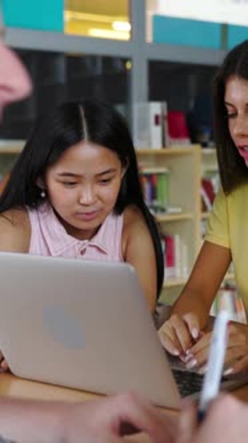 Young Group of Diverse Students Studying Together Using Laptop at Library