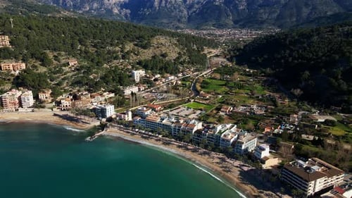 Beautiful reveal of Port Soller Mallorca Spain tropical sandy beach on hot summer day with village b