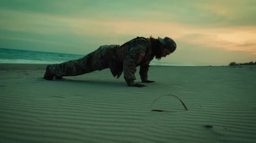 American Navy Soldier Does Pushups on the Beach at Sunset for Sports Training