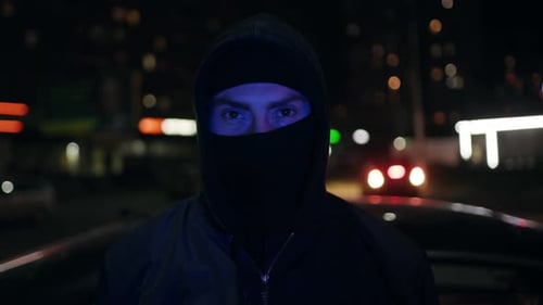 Hooded Figure with Police Lights at Night