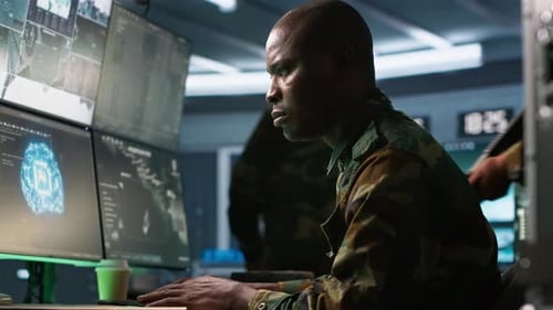 Man Working at Computer Station in Dark Room