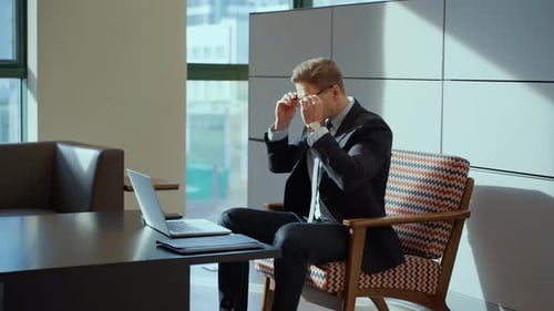 Stylish Caucasian Businessman Wears Eyeglasses and Starts Working Using Laptop Inside Cozy Office