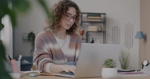 Ehrgeizige junge Unternehmerin, die von zu Hause aus arbeitet und am Laptop tippt, konzentriert sich auf das Internet