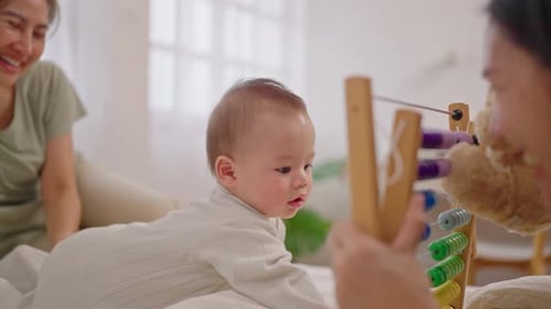 Happy Baby Playing with Toy with Family