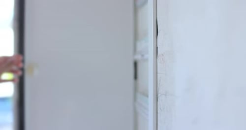 Man Check and Turn on Circuit Breakers in Electrical Fuse Box at House