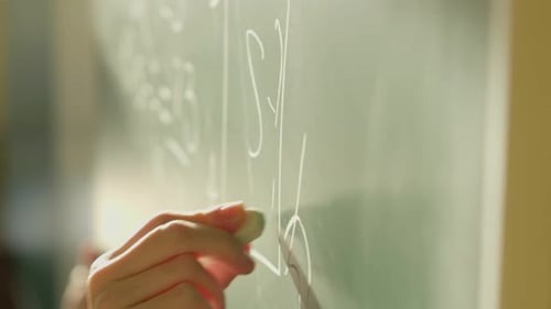 A Girl Student Writes on a Green Board