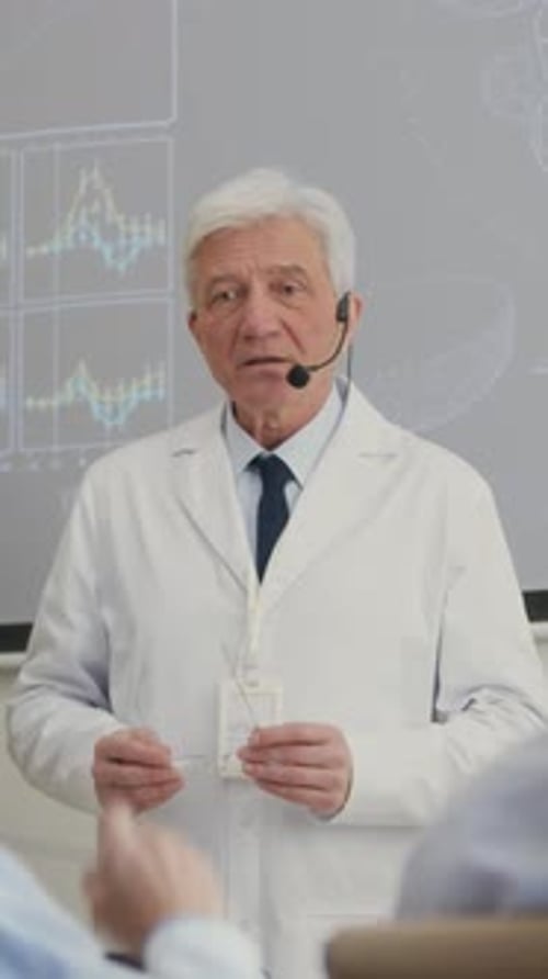 Senior Male Presenter Answering Colleagues Question during Medical Conference