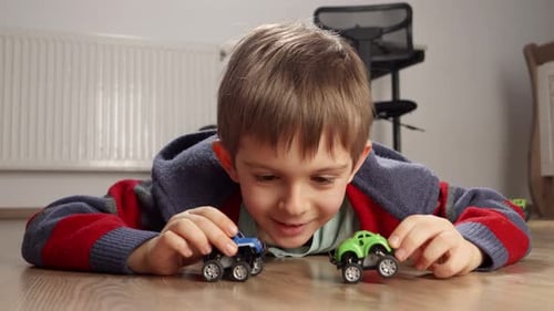 Happy Boy Playing with Toy Trucks on Floor
