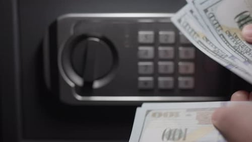 Um empresário está contando dinheiro com um cofre em segundo plano