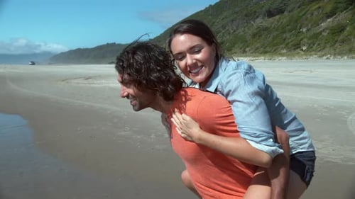 Couple laughing and playing in super slow motion on a tropical beach vacation