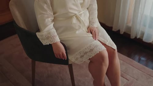 Woman in Robe Sits Near Window Indoors