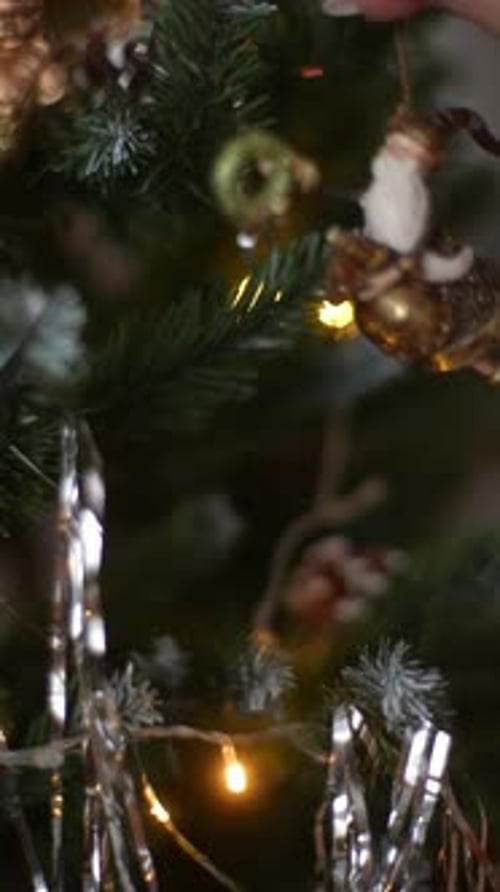 Vertical Cropped Shot of Female Decorating Christmas Tree with Santa Claus Riding Reindeer Ornament