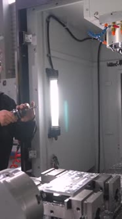 Man Working on Industrial Machine in Factory Setting