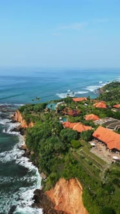 La vista aérea del complejo tropical revela villas de lujo con piscina infinita de color turquesa junto a las palmeras del océano azul