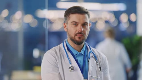 Serious man doctor in hospital setting looking at camera